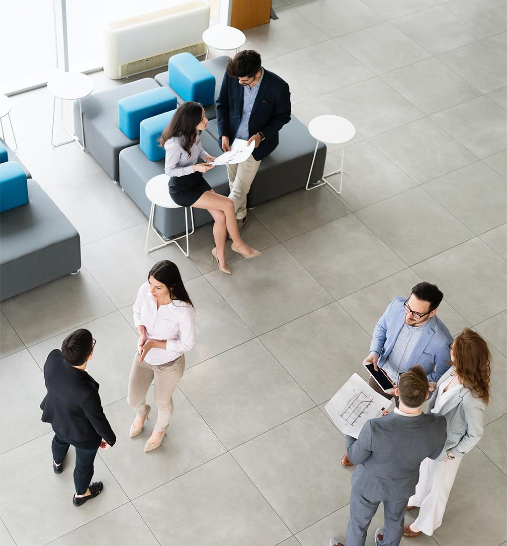 A high-angle view of a corporate office featuring groups of professionals discussing important business matters.